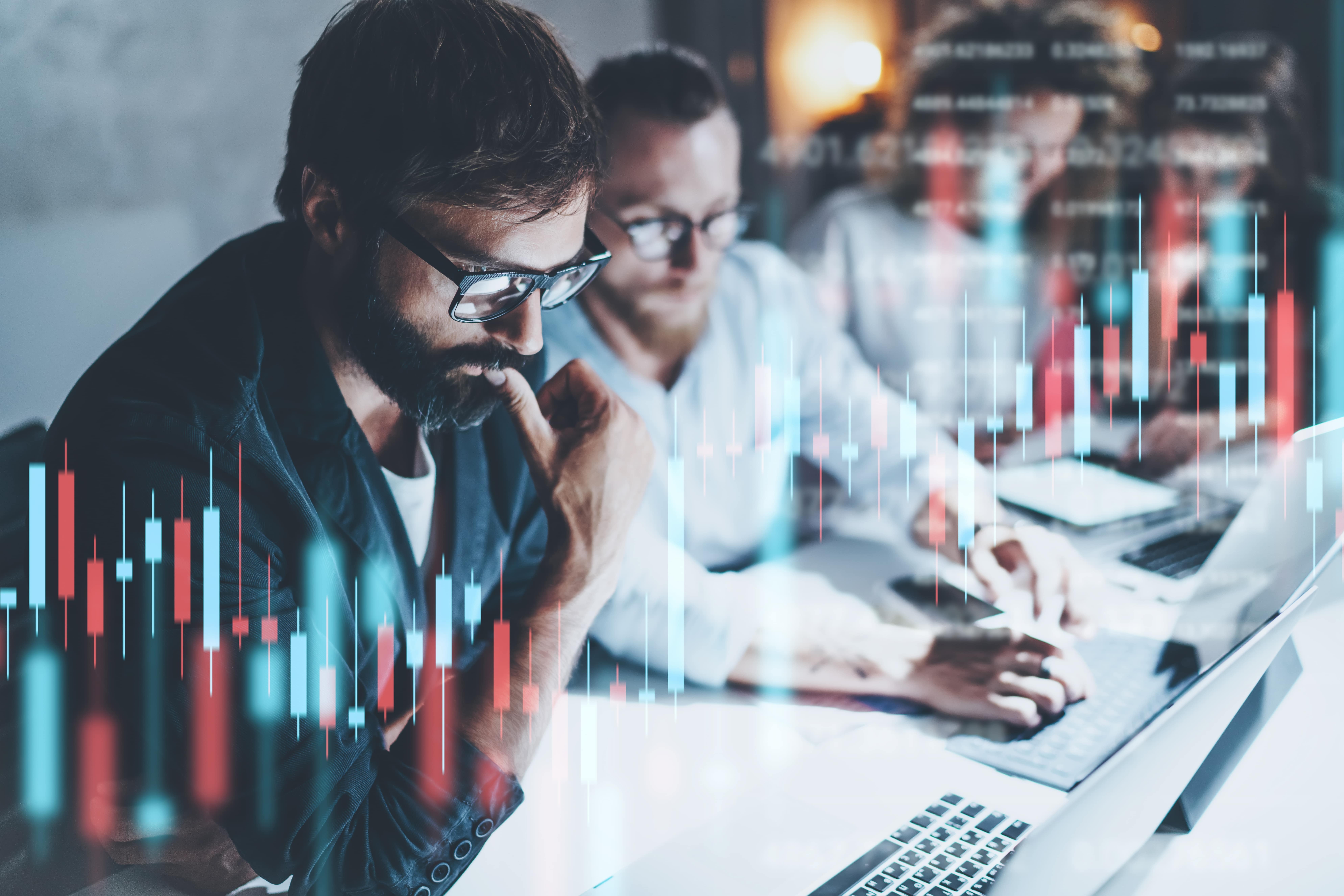 3 traders analyzing the financial markets.